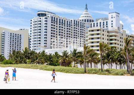 Miami Beach Florida, Loews, Hotel, 1998, Hotel, Hotels, Strand, Gebäude, öffentlicher Strand, hart verpackter Sand, Kokospalmen, künstliche Düne, Gras, Männer m Stockfoto