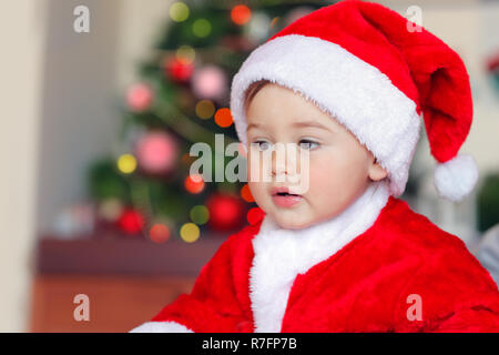 Porträt eines niedlichen kleinen Santa Claus, Pretty Boy das Tragen der roten festliche Kostüm Spaß zu Hause haben, frohe Weihnachten Zeit Stockfoto