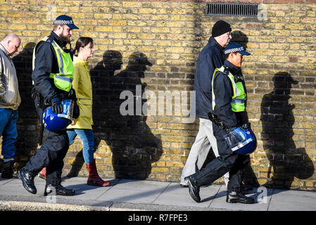 Brexit Verrat März in London Tagen vor der geplanten Abstimmung im Parlament. Polizeieskorte zu Fuß mit den Schatten an der Wand im hellen Sonnenlicht. Menschen Stockfoto