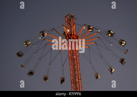 Rund um die Welt XXL-Achterbahn auf der South Bank, London, in der Abenddämmerung mit Licht. Messe Fahrt mit Menschen in den Stühlen hängen von rotierenden Arme Stockfoto