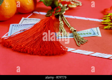 Gerne amerikanische Dollar das chinesische Neujahr mit traditionellen Dekorationen auf rotem Hintergrund. Stockfoto