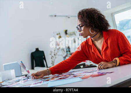 Curly effektive Frau Kontrolle Bild in Ihrer Hand Stockfoto