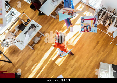 Whirling kurzhaarige curly Frau kindisch benehmen in der Mitte von Studio Stockfoto