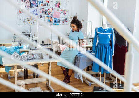 Beschäftigt gut aussehende Designer lehnte sich auf Tisch Stockfoto