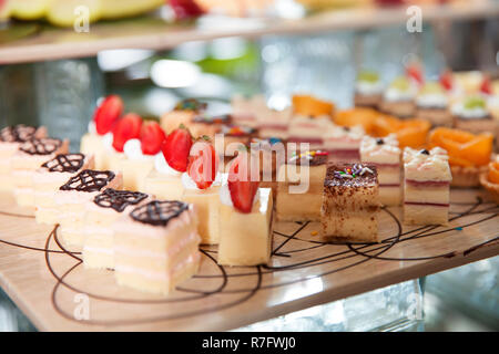 Leckere mini Kuchen mit Sahne, Schokolade und Erdbeeren auf Buffet. Catering Konzept Stockfoto