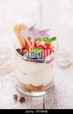 Hausgemachte italienische Dessert Tiramisu mit Erdbeeren, Minze und Kakao in Gläsern, Nahaufnahme Stockfoto