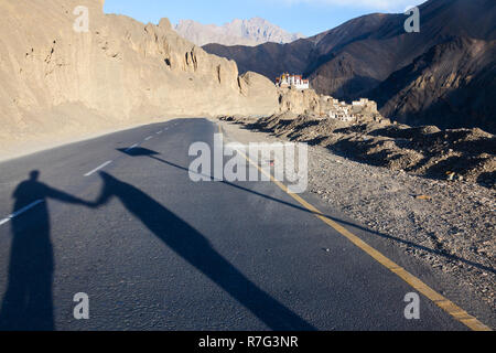 Lange Schatten der Paar Hände halten und stehen auf der Verbindungsstraße von Srinagar und Leh (NH1), in der Nähe von Lamayuru, Ladakh, Jammu und Kaschmir, Indien Stockfoto