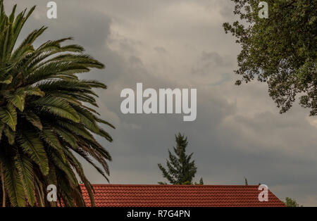 Gewitterwolken über den Dächern der Häuser in einem Wohnviertel Bild mit Kopie Raum im Querformat. Stockfoto