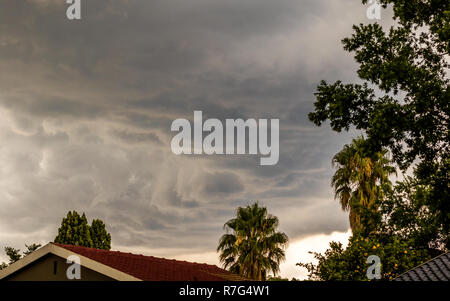 Gewitterwolken über den Dächern der Häuser in einem Wohnviertel Bild mit Kopie Raum im Querformat. Stockfoto