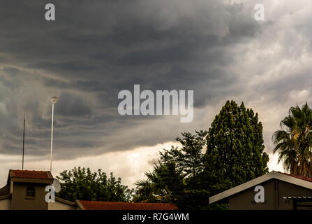 Gewitterwolken über den Dächern der Häuser in einem Wohnviertel Bild mit Kopie Raum im Querformat. Stockfoto