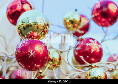 Goldene und rote Weihnachtskugeln mit street Reflexionen hängen auf dekorative Holz- baum Outdoor. Abstrakte festlichen Hintergrund Kopie Raum Stockfoto