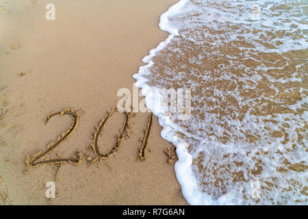 Die 2018 in den Sand geschrieben, während die Welle ist die 8 symbolisiert das Ende des Jahres. Stockfoto