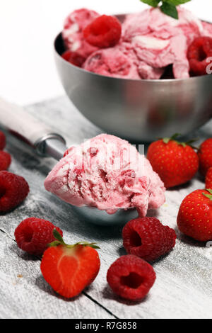 Erdbeere und Himbeere Eisportionierer mit gehackten Nüssen und weißer Schokolade auf einem urigen Hintergrund Stockfoto