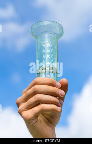 Hand gefüllt Wasserzähler in blauer Himmel mit Wolken Stockfoto