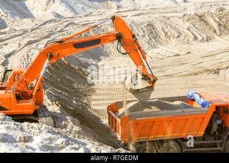 Arbeit der Bagger und Lkw an einer sand Steinbruch. Bagger laden Sand in einen Dump Truck. Stockfoto