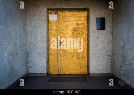 In gold Tür mit einem blau-weiße Wand gemalt. Abstrakte leer vertikale Hintergrund einer Holztür mit abblätternder Farbe und Wände. Stockfoto