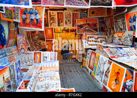 Der Souk von Marrakesch - ein Unternehmer, der bunten Bilder und Gemälde in einem Markt, in den Souks ausgeht, Medina von Marrakesch, Marrakesch, Marokko Nordafrika Stockfoto