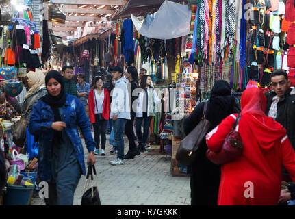 Touristen und Einheimische einkaufen und Kauf von Waren im Souk, Medina von Marrakesch, Marrakesch, Marokko, Afrika Stockfoto