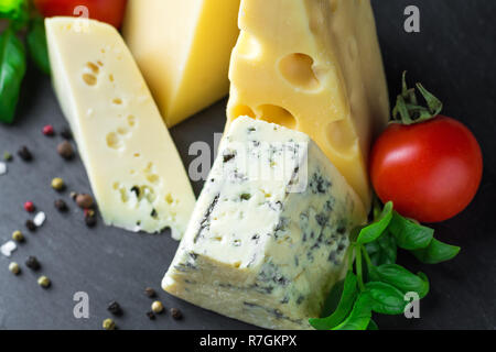Verschiedene Arten von Käse, Tomaten und Basilikum Blätter in der Nähe von Stockfoto