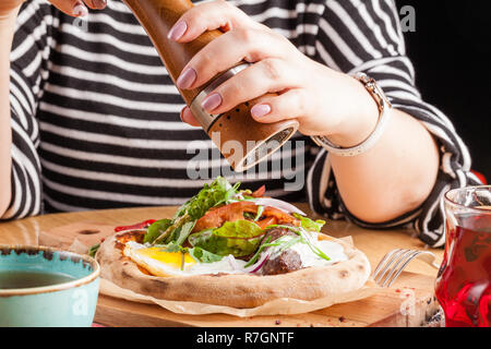 Junge Frau Frühstücken in Street Cafe Stockfoto