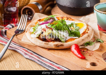 Weibliche essen Eier Benedikt auf geröstetem Muffins mit Schinken und Sauce Stockfoto