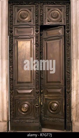 Antike hölzerne massive halb geöffnete Tür mit geschnitzten Ornament und Kupfer Regler Stockfoto