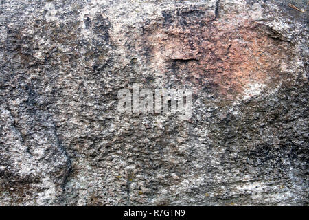 Unebene Oberfläche der großen grauen Granit Boulder mit rosa Aufnahme kann als Hintergrund- oder Textur verwendet werden. Stockfoto