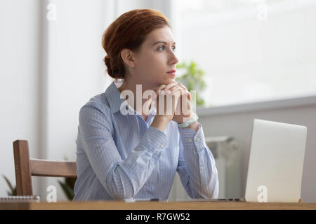 In Gedanken Frau verlor sitzt am Arbeitsplatz Schreibtisch im Büro Stockfoto