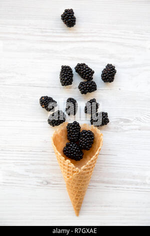 Süße Waffel Eiswaffel mit Brombeeren auf weißem Holz- Hintergrund, Ansicht von oben. Flach, Overhead, von oben. Stockfoto