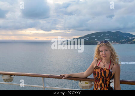 Blonde Frau auf Kreuzfahrtschiff mit Blick auf den Sonnenuntergang in Philipsburg, St. Martin Stockfoto