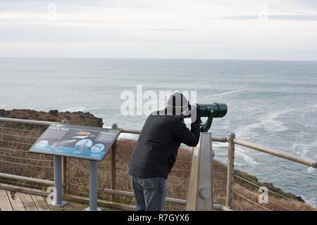 Ein Mann durch eine Münze suchen - Fernglas bei Yaquina Head in Newport, Oregon, USA betrieben. Stockfoto