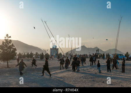 Versuch, einen Drachen mit einem Gegabelten Stock auf einen Freitag Abend an der Spitze eines Hügels, Kabul, Provinz Kabul, Afghanistan zu fangen Stockfoto