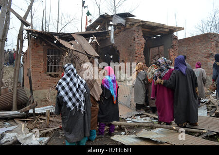 Srinagar, Jammu und Kaschmir, Indien. 9 Dez, 2018. Kaschmirischen Volkes prüfen Krieg verwüsteten Häusern, in denen Aktivisten während der Schusswechsel mit der indischen Regierung Kräfte im Bereich der Mujgund Srinagar, die Hauptstadt des Indischen verwalteten Kaschmir, Indien durchlöchert waren. Vierzehn Jahre alten Jungen unter den drei Kämpfer in die Pistole Kampf getötet. Sechs Wohnhäuser wurden auch beschädigt. Credit: Masrat Zahra/ZUMA Draht/Alamy leben Nachrichten Stockfoto