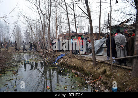 Srinagar, Jammu und Kaschmir, Indien. 9 Dez, 2018. Kaschmirischen Volkes prüfen Krieg verwüsteten Häusern, in denen Aktivisten während der Schusswechsel mit der indischen Regierung Kräfte im Bereich der Mujgund Srinagar, die Hauptstadt des Indischen verwalteten Kaschmir, Indien durchlöchert waren. Vierzehn Jahre alten Jungen unter den drei Kämpfer in die Pistole Kampf getötet. Sechs Wohnhäuser wurden auch beschädigt. Credit: Masrat Zahra/ZUMA Draht/Alamy leben Nachrichten Stockfoto