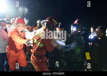 (181210) - CHENGDU, 10.12.2018 (Xinhua) - ein Überlebender ist auf der Website von Erdrutsch im Fenshui Stadt Xuyong Grafschaft gefunden, im Südwesten Chinas Provinz Sichuan, Dez. 9, 2018. Der Erdrutsch hit Fenshui Stadt Sonntag Nachmittag, wobei 11 Menschen begraben und eine fehlt. Ab 1:00 Uhr (GMT 0500) Montag, den 11 begraben alle aus den Trümmern gezogen wurden und vier von ihnen waren tot. Mehr als 1.000 Menschen in die Rettungsarbeiten beteiligt. (Xinhua / Su Zhongguo) (yxb) Stockfoto