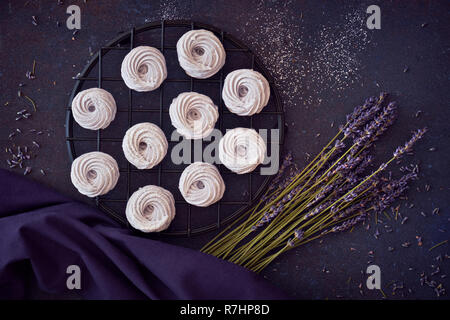 Flach mit einem Teller hausgemachte Marshmallows (Zephyr, Baiser) mit Lavendel auf dunklem Hintergrund gemacht Stockfoto