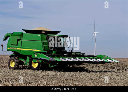 Ingalls Kansas, USA, 24. Oktober 2014 eine John Deere Mähdrescher schickt seine Last von Milo Korn aus dem Vorratsbehälter durch das Rohr in das Bett einer Wartezeit Traktoren Anhänger entladen, damit es den Tausenden von scheffel von Sorghum an die lokalen Co-op, wo es als Tierfutter verwendet wird. Über 100 Bushel ein Morgen von dieser Hälfte Abschnitt am LeRoy Anderson Bauernhof in Ingalls Kansas Credit: Mark Reinstein/MediaPunch Stockfoto