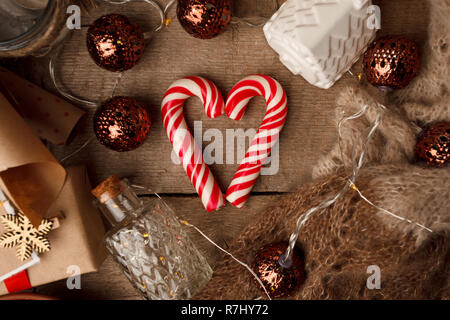 Weihnachten Stillleben mit Nüssen, traditionelle Weihnachten candy heart-shaped, festliche Dekoration, Kraftpapier, Geschenkboxen auf vintage Holz- Hintergrund, Tradit Stockfoto