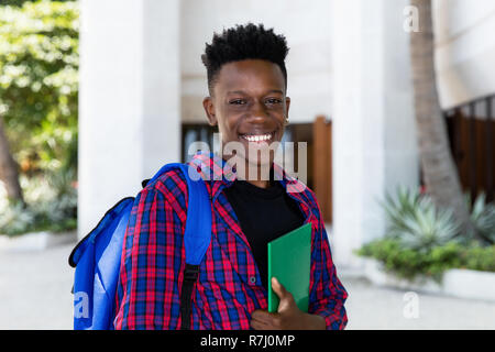 African American männliche Kursteilnehmer mit Buch im Freien in der Stadt Stockfoto