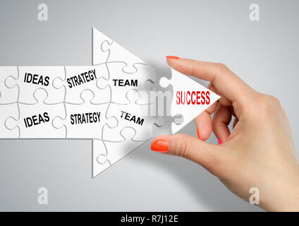Weg zum Erfolg durch Ideen, Strategie und Team, Hand baut Pfeil mit Puzzles Stockfoto