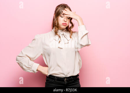 Ernsthafte unglücklich weiblichen ansprechend Aussehen hat, nachdem er mit der Person Streit traurig, Stirnrunzeln, das Gesicht in Unzufriedenheit, über Pink Studio Hintergrund isoliert. Die negative Emotionen Konzept Stockfoto