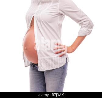 Schwangere Frau in einem weißen Hemd und Jeans auf einem weißen Hintergrund. Stockfoto