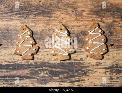 Drei Lebkuchen Weihnachten Kekse in einer Reihe, auf einer hölzernen Hintergrund, Landschaft Zusammensetzung Stockfoto