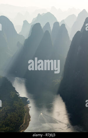 Vertikale Foto von Hügeln in Silhouette in der Sonnenaufgang über Li River ab Xianggong Mountain in der Nähe von Guilin, China gesehen. Sonnenstrahlen zwischen Hügeln glänzen. Stockfoto