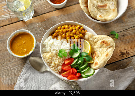 Vegetarische buddha Schüssel mit Naan Brot auf Holztisch, Ansicht von oben. Gesunde vegetarische Essen Konzept Stockfoto