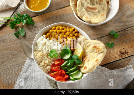 Vegan buddha Schüssel mit Naan Brot auf Holztisch, Ansicht von oben. Gesunde vegetarische Essen Konzept Stockfoto
