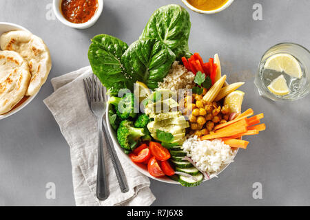Vegan buddha Schüssel mit Naan Brot auf grauem Beton Hintergrund der Ansicht von oben. Gesunde vegane Ernährung Konzept Stockfoto