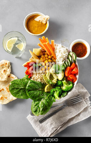 Vegan buddha Schüssel mit Naan Brot auf grauem Beton Hintergrund der Ansicht von oben. Gesunde vegane Ernährung Konzept Stockfoto