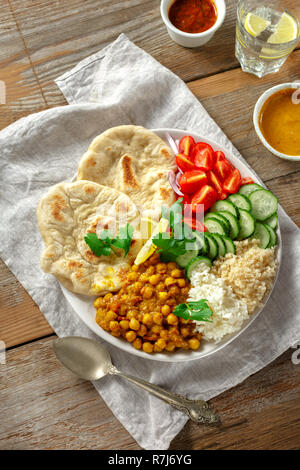 Quinoa, Kichererbsen, Reis, Gemüse vegetarische Buddha Schüssel auf Holztisch, Ansicht von oben. Gesunde Ernährung Stockfoto