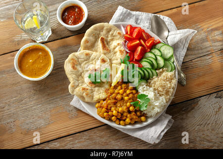 Quinoa, Kichererbsen, Reis, Gemüse vegetarische Buddha Schüssel auf Holztisch, Ansicht von oben. Gesunde Ernährung Stockfoto